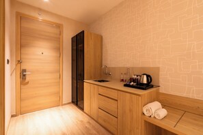 Un baño moderno con tocador de madera, lavamanos y un perchero para toallas.