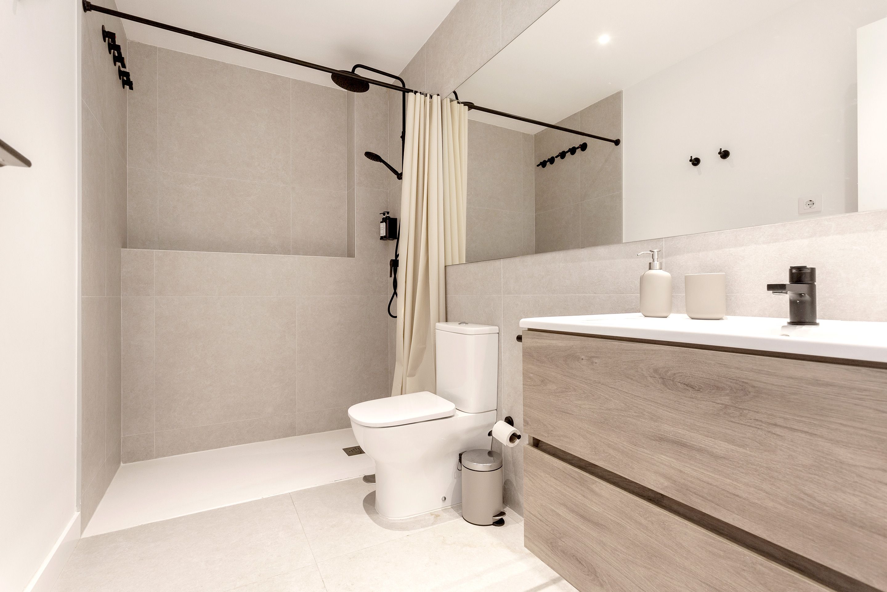 Une salle de bain moderne équipée d’une douche, de toilettes et d’un meuble-lavabo.