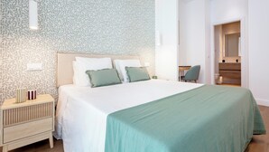 Een moderne slaapkamer met een groot bed, een nachtkastje en een stoel.