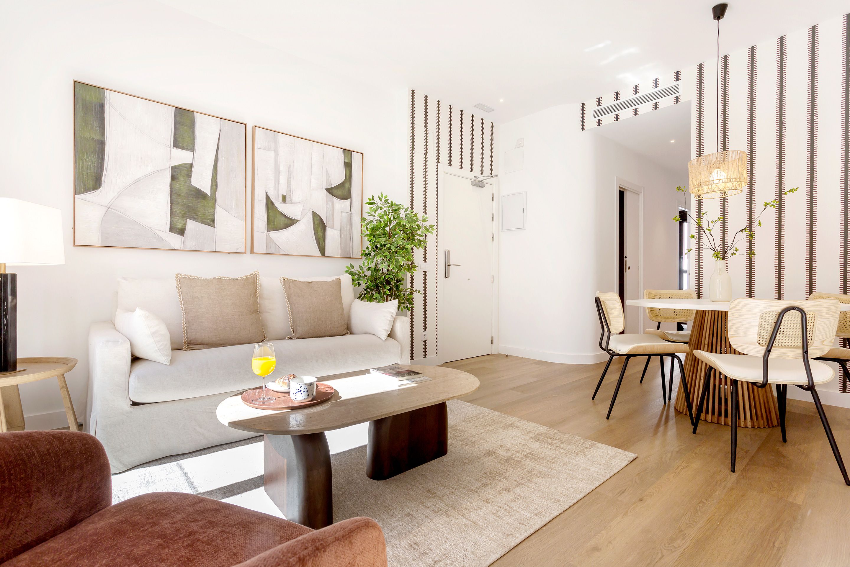 A modern living room with a sofa, coffee table, and dining area.