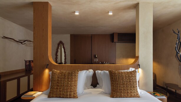 A hotel room with a large bed, wooden headboard, and a built-in desk area. - Íz Hotel Conceito (Goiânia)