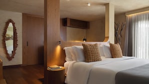 A modern hotel room with a large bed, wooden headboard, and a decorative mirror. - Íz Hotel Conceito (Goiânia)