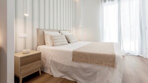 A modern bedroom with a large bed, a bedside table, and a window with sheer curtains. - Genteel Home Zabaleta III (Madrid)