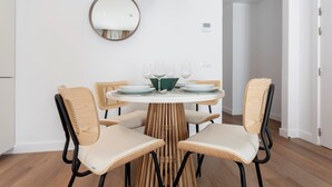 A dining area with a round table, four chairs, a mirror, and a hanging light fixture. - Genteel Home Zabaleta III (Madrid)