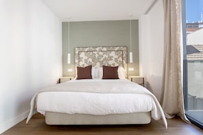 A large bed with a headboard, bedside tables, and a window with curtains. - Genteel Home Zabaleta Terrace V (Madrid)