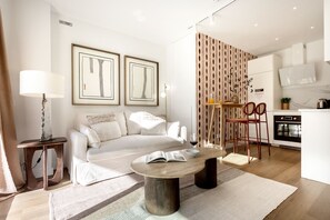 Een moderne woonkamer met een bank, salontafel en een eethoek met stoelen.
