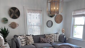 A cozy living room with a sectional sofa, a wooden coffee table, and a patterned rug. - Designed for You - Beautifully Renovated 2 Bedroom (Pawtucket)