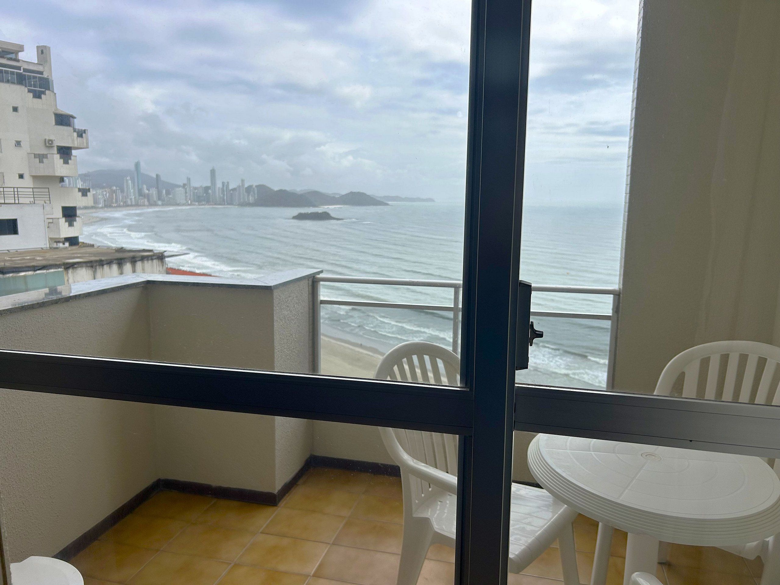 Un balcón con vista al océano y al horizonte de la ciudad.