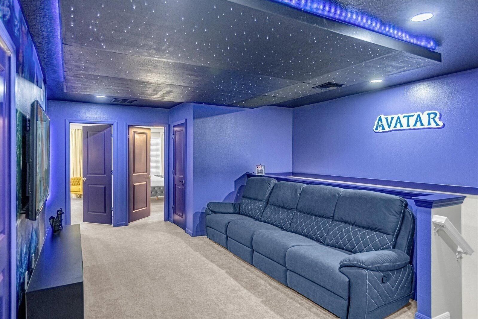 A room with a starry ceiling, a blue couch, and a wall-mounted sign that reads "AVATAR".