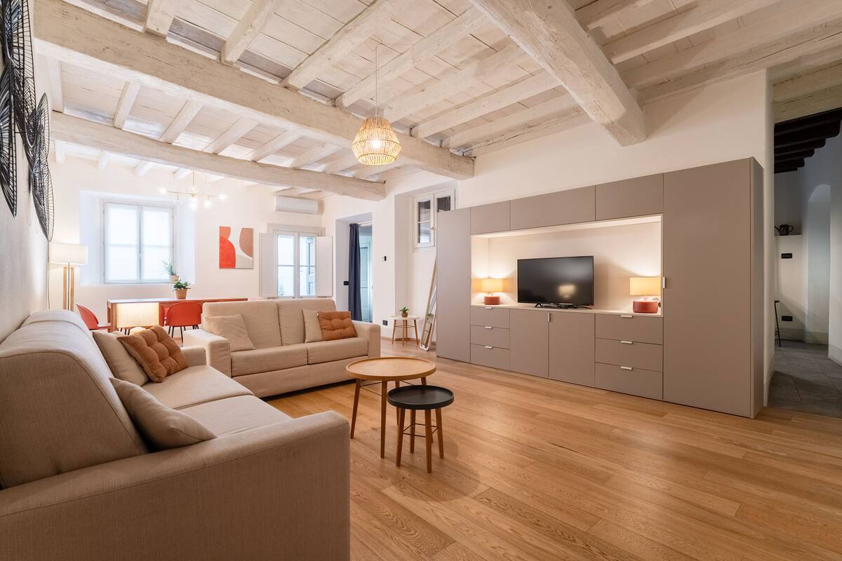 Un vaste espace de vie comprenant un canapé, un téléviseur et une table à manger.