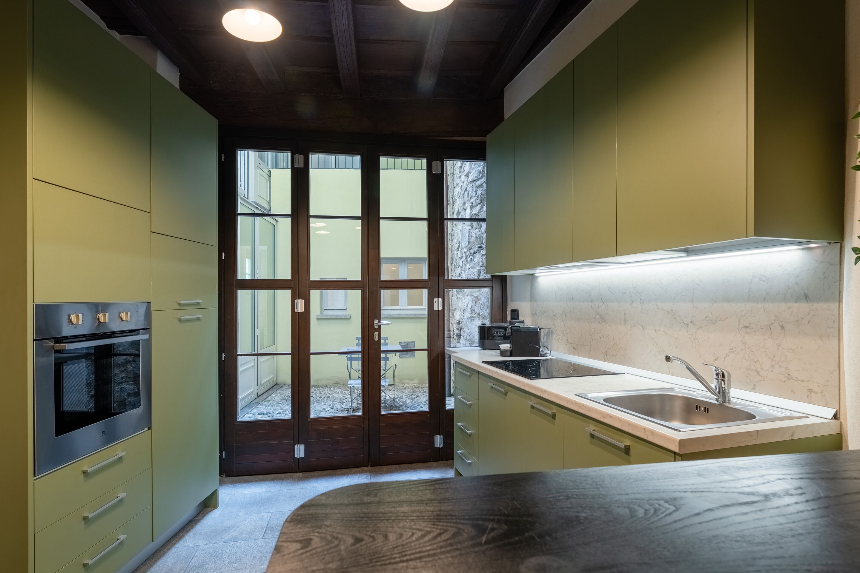 Una cocina moderna con horno integrado, pileta y encimera.