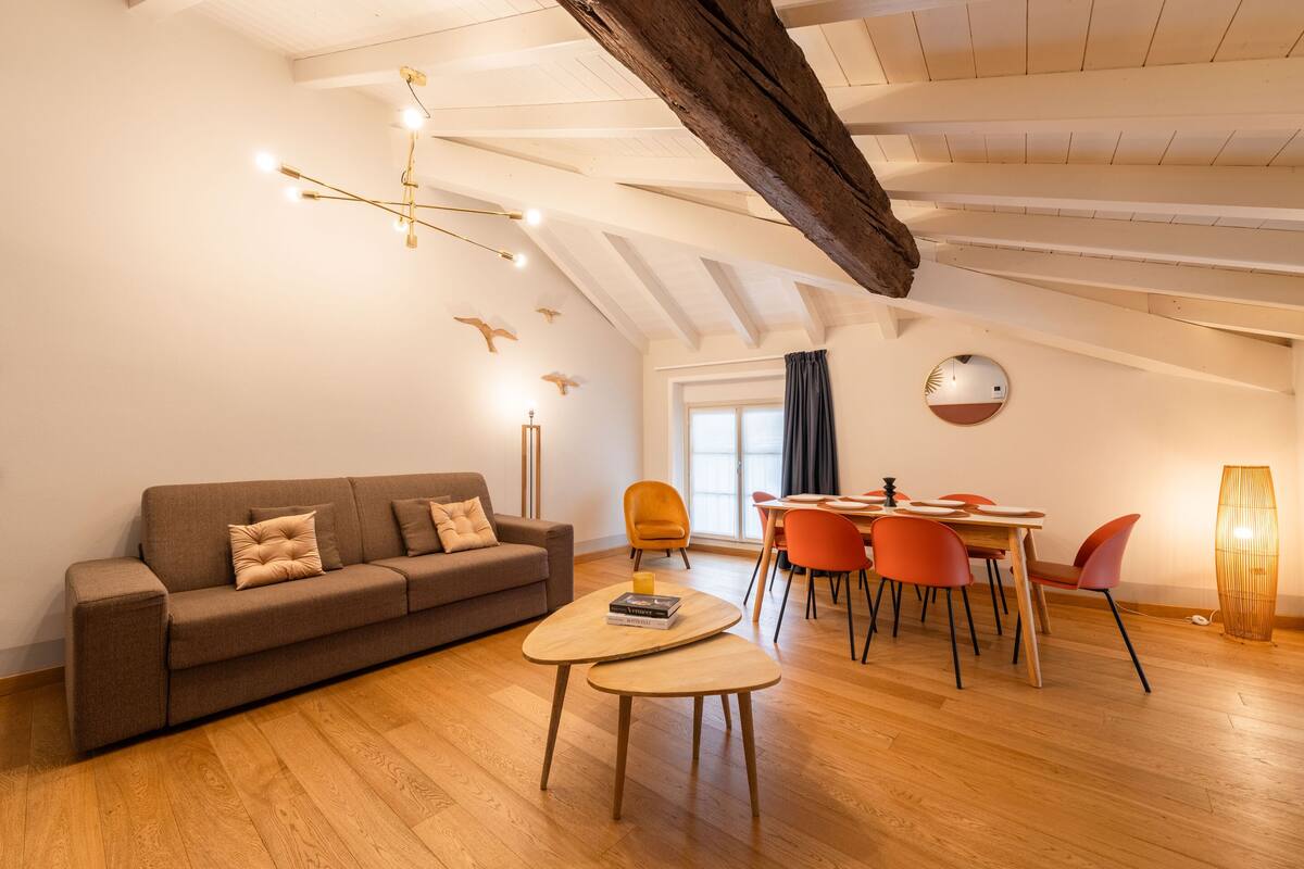 Un salon moderne comprenant un canapé, une table basse, une table à manger et des chaises.