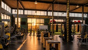 A gym with various exercise equipment, a sign that reads 'MOVE YOUR COMFORT ZONE', and large windows allowing natural light. - Family - Elegant - Smart Home (Midrand)