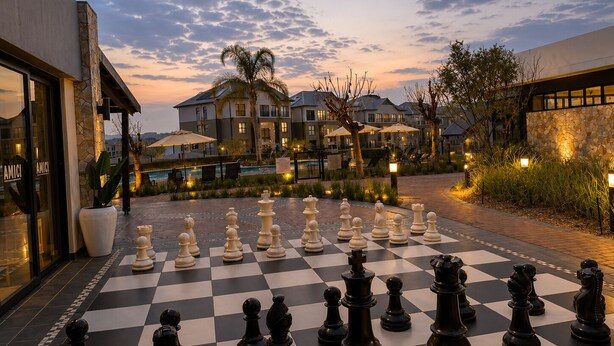 A chessboard set up outdoors with a building in the background. - Family - Elegant - Smart Home (Midrand)
