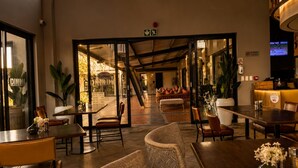 A restaurant interior with a bar area, seating arrangements, and a visible exit sign. - Family - Elegant - Smart Home (Midrand)