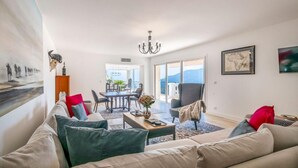 A spacious living room with a sofa, coffee table, and a dining area with chairs. - Villa Les Adrets Mandelieu Hillside With Pool - 2303 (Fréjus)