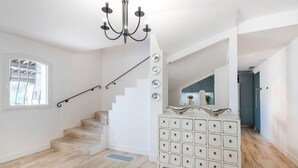 A spacious room with a staircase, a white dresser with multiple drawers, and a chandelier. - Villa Les Adrets Mandelieu Hillside With Pool - 2303 (Fréjus)