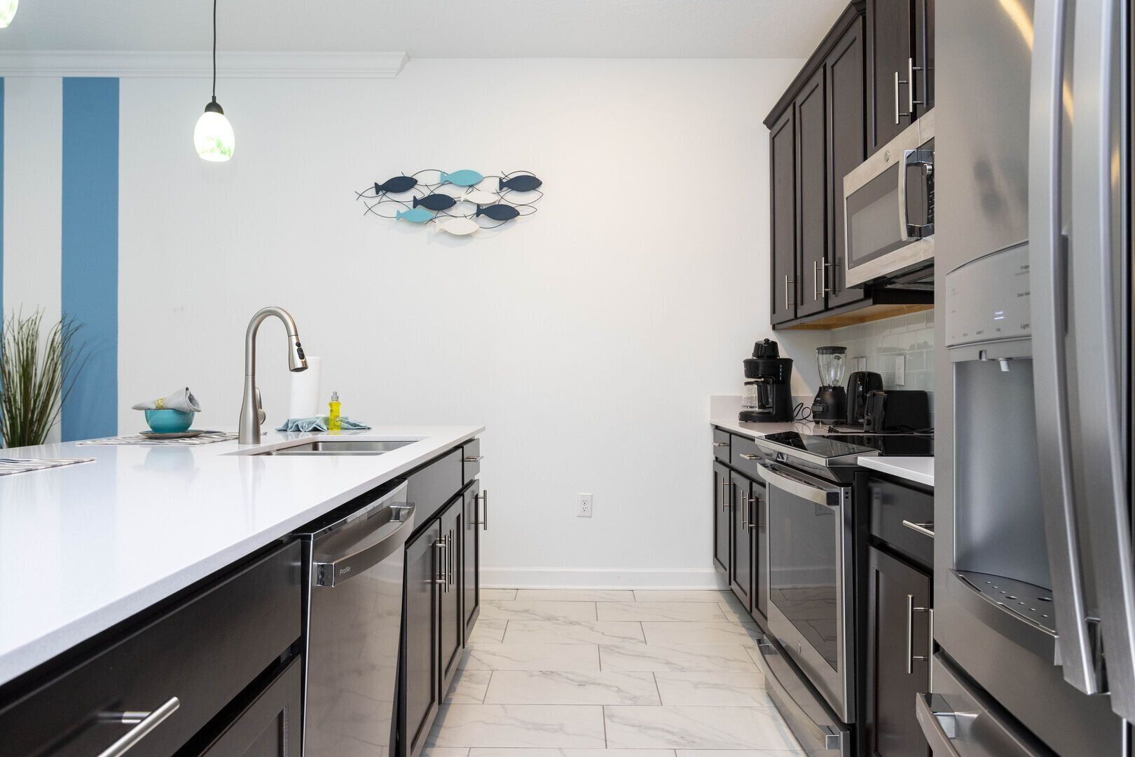 Una cucina moderna con un'isola grande, elettrodomestici in acciaio inossidabile e un elemento decorativo a parete.
