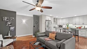 A modern living room with a gray sofa, a coffee table, and a ceiling fan. - St Louis Co- Tranquil 2-bed/1 bath house -STL County-Sleeps 1-4 (Ballwin)