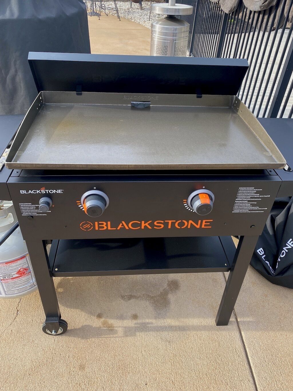 A BLACKSTONE portable grill with a flat cooking surface and two control knobs.