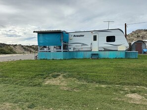 A mobile home with a covered porch and a small attached structure.