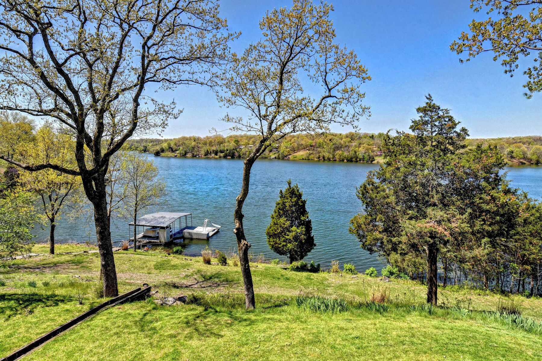 A lakeside view with a dock and a small boat.