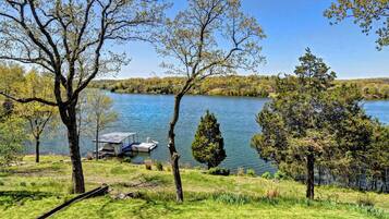 A lakeside view with a dock and a small boat.