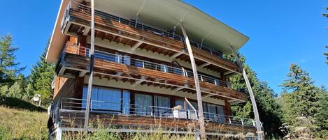 A multi-story building with a wooden facade and balconies.