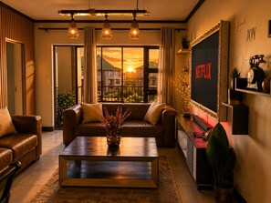 Ein Wohnzimmer mit Ledersofa, Couchtisch und Wand-Fernseher.