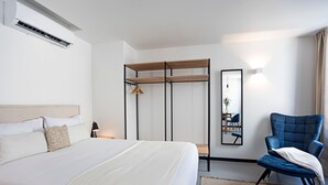 A hotel room with a bed, a chair, a wardrobe, and a mirror. - Regras Apartments & Garden A1 by Benefit Collection (Porto)