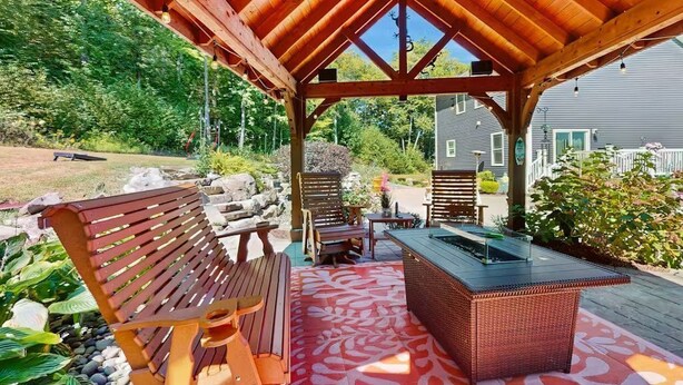 Eine Terrasse im Freien mit einer Holzbank, einem Tisch und einer Bar.