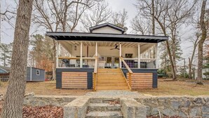 Een modern huis met een overdekte veranda, stenen trappen en een basketbalring.
