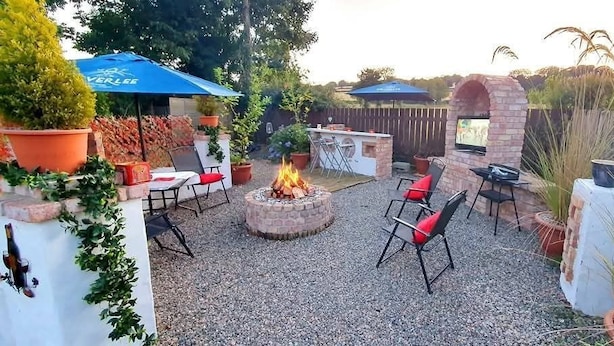 An outdoor patio with a fire pit, seating, and a TV. - Casa Douglas (Lifford)