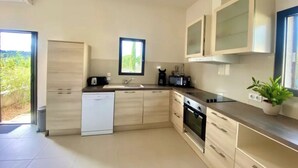 A modern kitchen with a dishwasher, oven, microwave, and cabinets. - Château Juliette 4* Provence wine estate (Tresques)