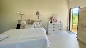 A bedroom with a bed, bedside table, and a view of the outdoors. - Château Juliette 4* Provence wine estate (Tresques)