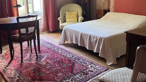 A bedroom with a bed, a desk, a chair, a rug, a clock, and a lamp. - Large family home in the country - sleeps 8 (Saint-Seine-sur-Vingeanne)