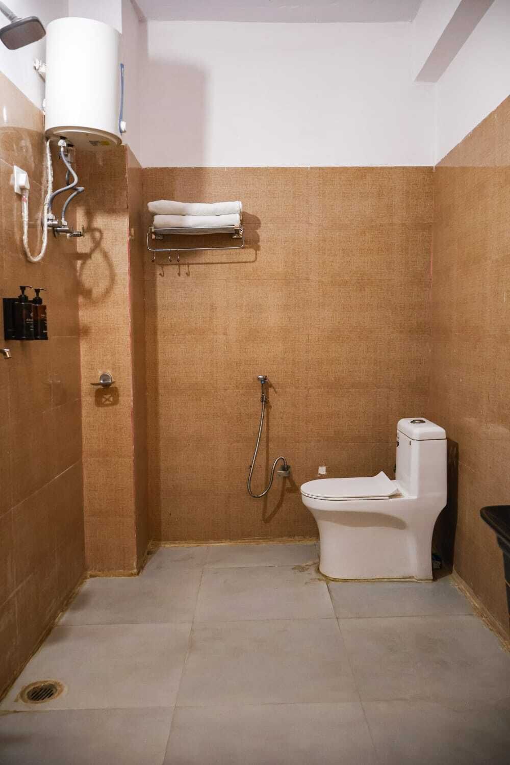 A small bathroom with a toilet, shower, and towel rack.