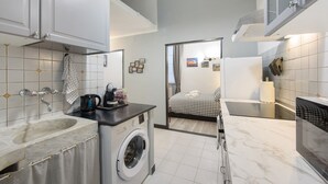 A compact kitchen with a washing machine, a sink, and a countertop.