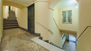 A staircase with handrails, a door, and a window with a metal grille.