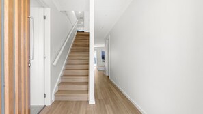 A modern interior with a wooden staircase, white walls, and a clean, minimalist design. - Callala Chill Jervis Bay - Short Walk to Creek (Callala Bay)