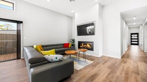 Smart TV, lareira, livros, aparelho de som