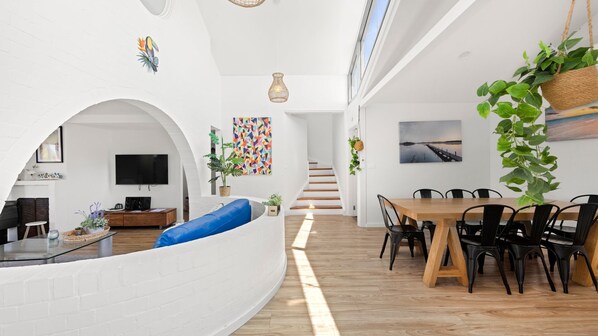 Een modern interieur met een eethoek, een zithoek en een trap.