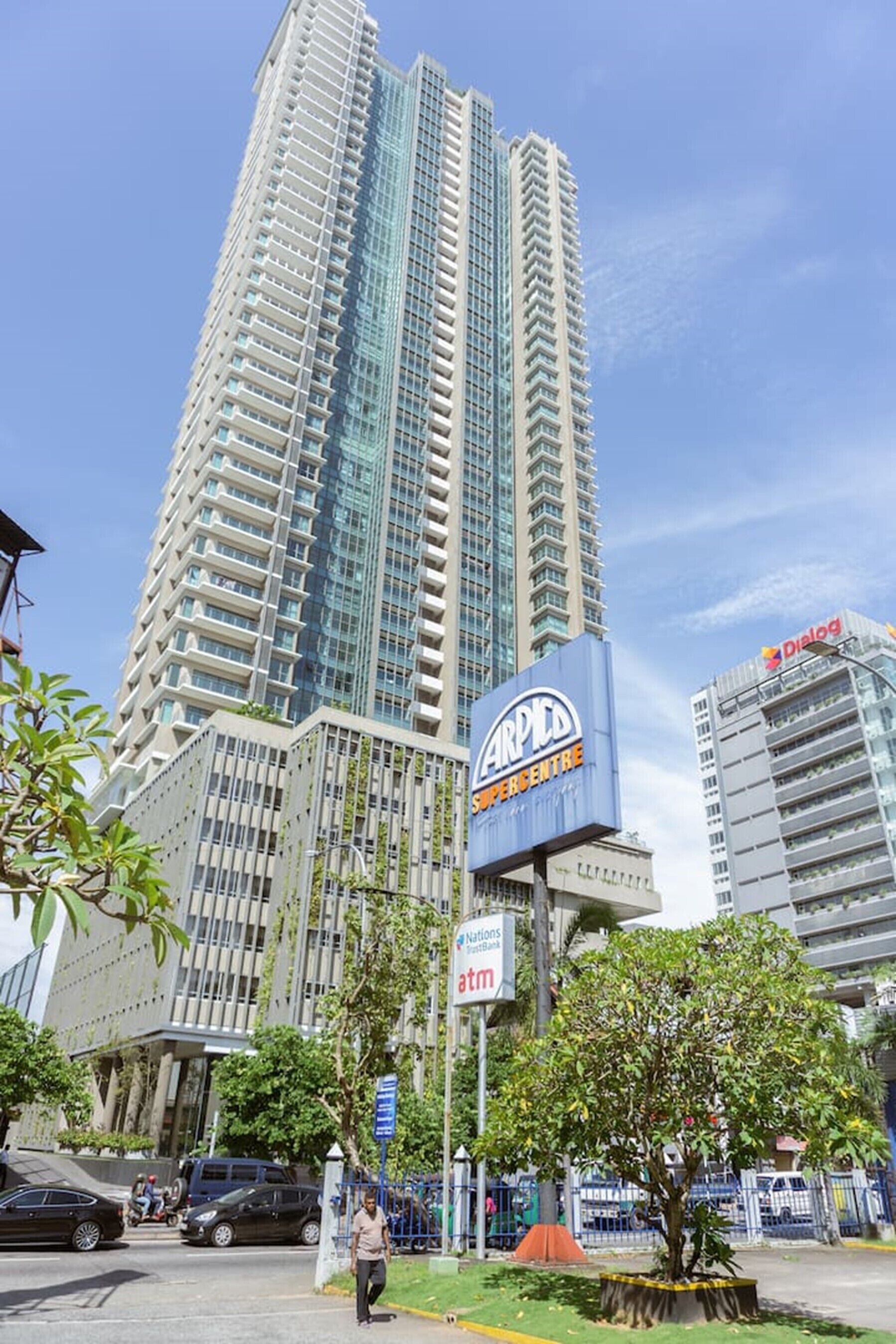 Un edificio moderno y alto con un cartel que dice "Carpenter Supercentre" y un cajero automático de Nations Bank.