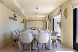 A dining area with a long table, multiple chairs, and a modern interior design. - Hotel Hospes Maricel & Spa (Ca's Catala)