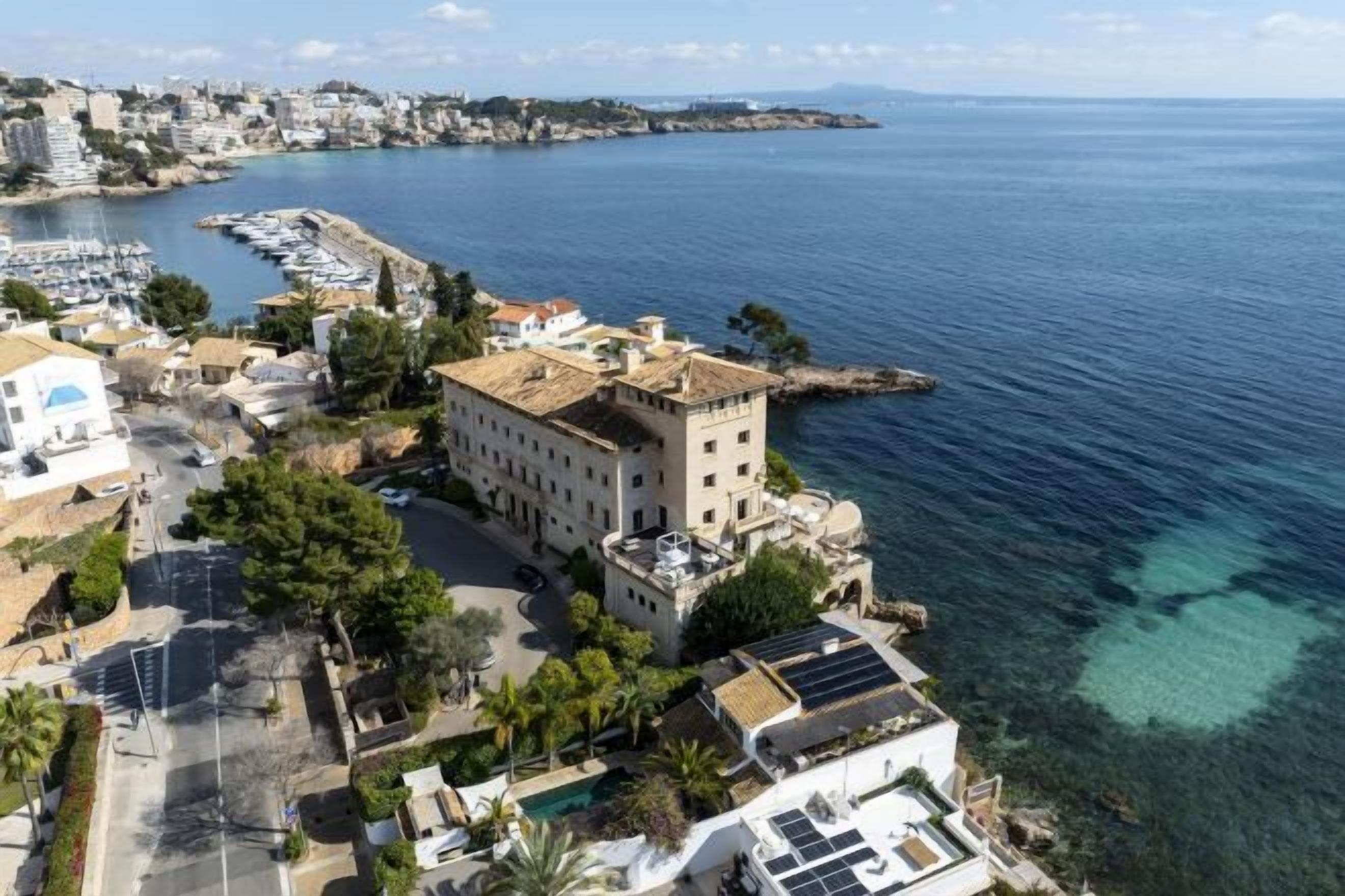 Un pueblo costero con edificios cerca del agua, incluyendo un edificio destacado con una torre.