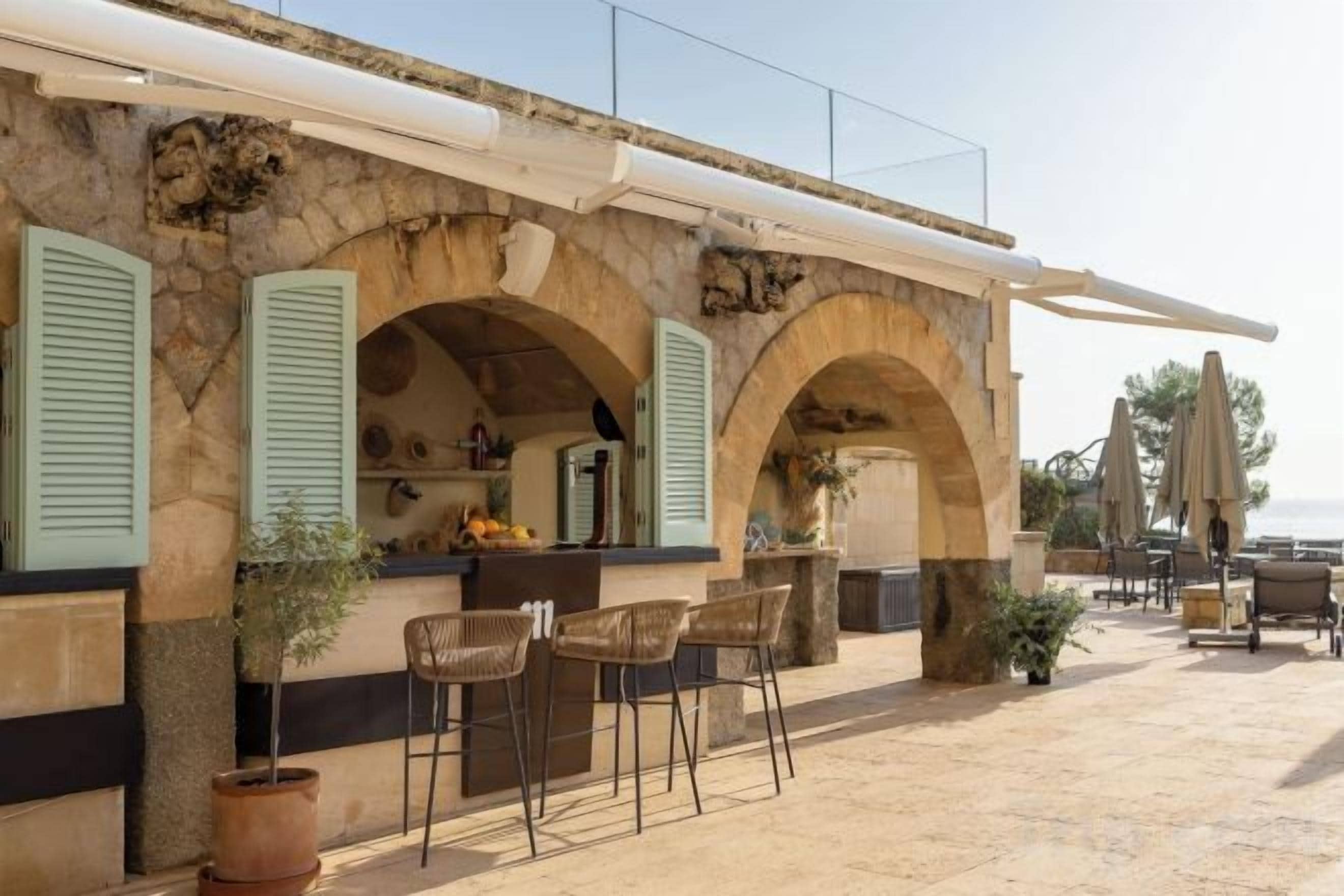 Un edificio de piedra con mesas al aire libre y una zona de bar.