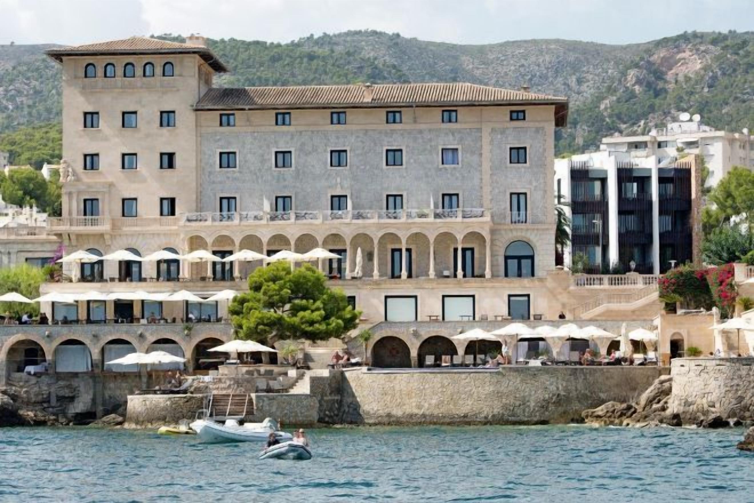 Un hotel frente al mar con varios balcones, una zona de piscina y vistas al océano.