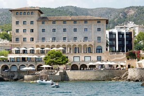 A coastal hotel with multiple balconies, a pool area, and a view of the sea. - Hotel Hospes Maricel & Spa (Ca's Catala)