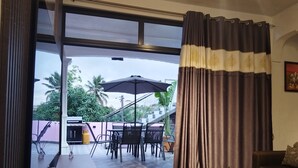 A living room with a large sliding glass door leading to an outdoor patio area. - Villa atomium ile maurice souillac 127m2 100m to the beach (Souillac)