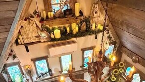 A loft-style room with a wooden ceiling, a chandelier, a sofa, a coffee table, and a red rug with a white symbol. - The Wizard's Retreat near Top Attractions! (Sevierville)